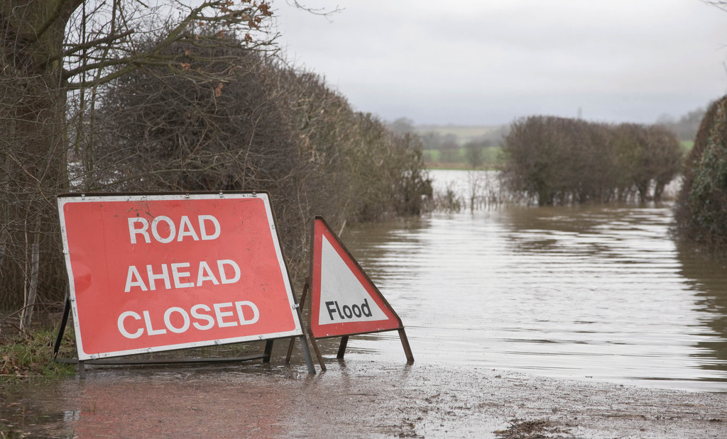 extreme weather - flooded road with road signs